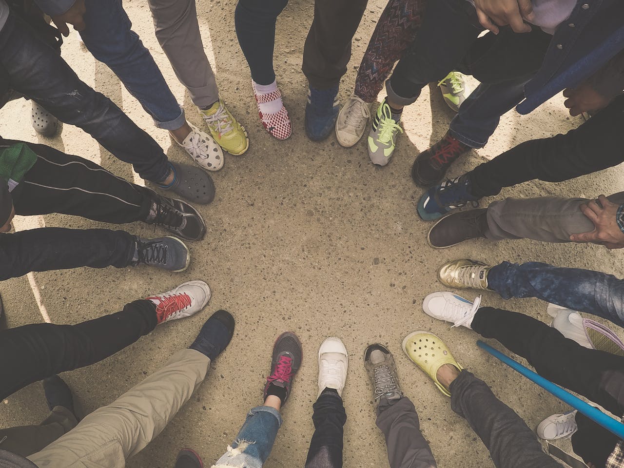 A group of people forming a circle with their sneakers, symbolizing diversity and unity.