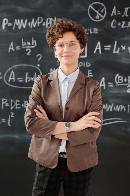 Portrait of a teacher standing in front of a blackboard full of mathematical equations.